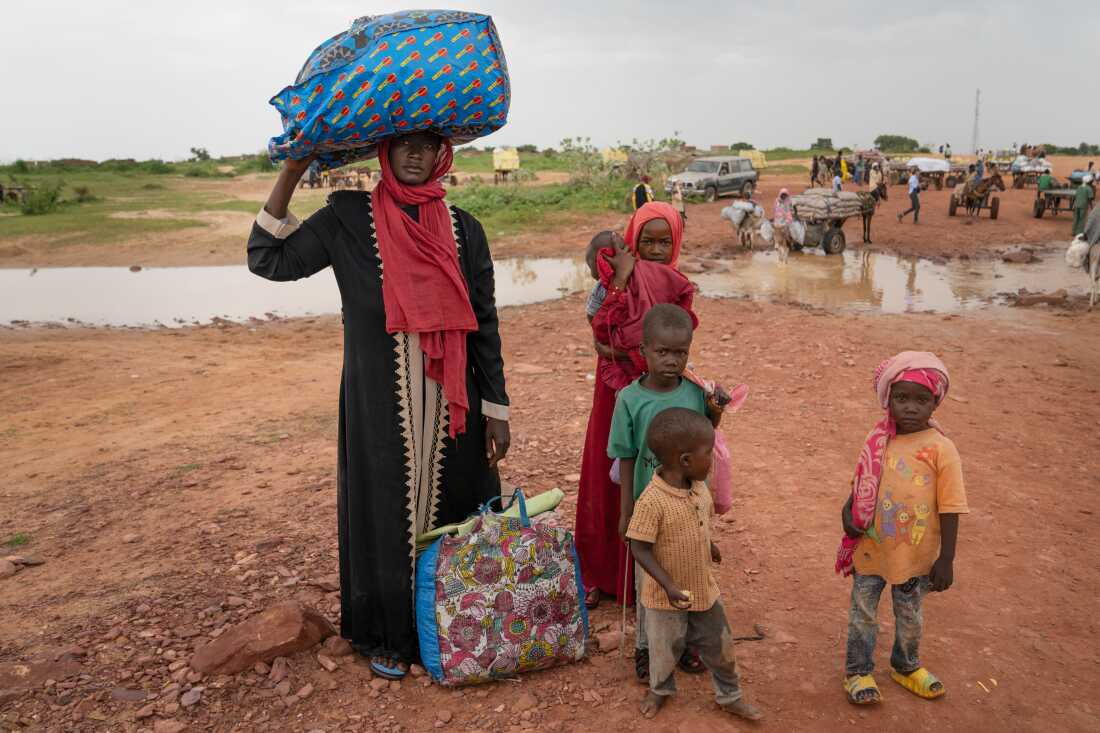 Awatif Zakaria Omar Ahmed, 29, enters Chad from Sudan for the first time at the Adré border crossing, with her 5 children and carrying all of their belongings.