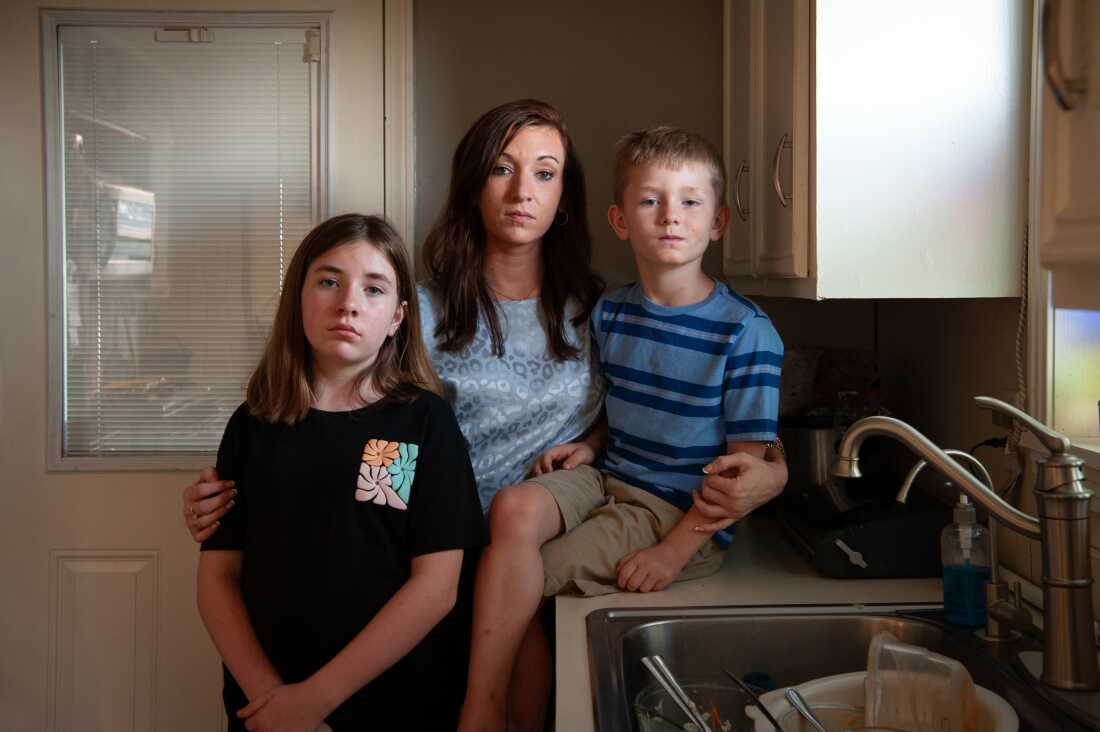 In this photo, Caitlyn Kelly and daughter Annadale Norris stand in the kitchen, while son Logan White sits on the counter, next to the sink.