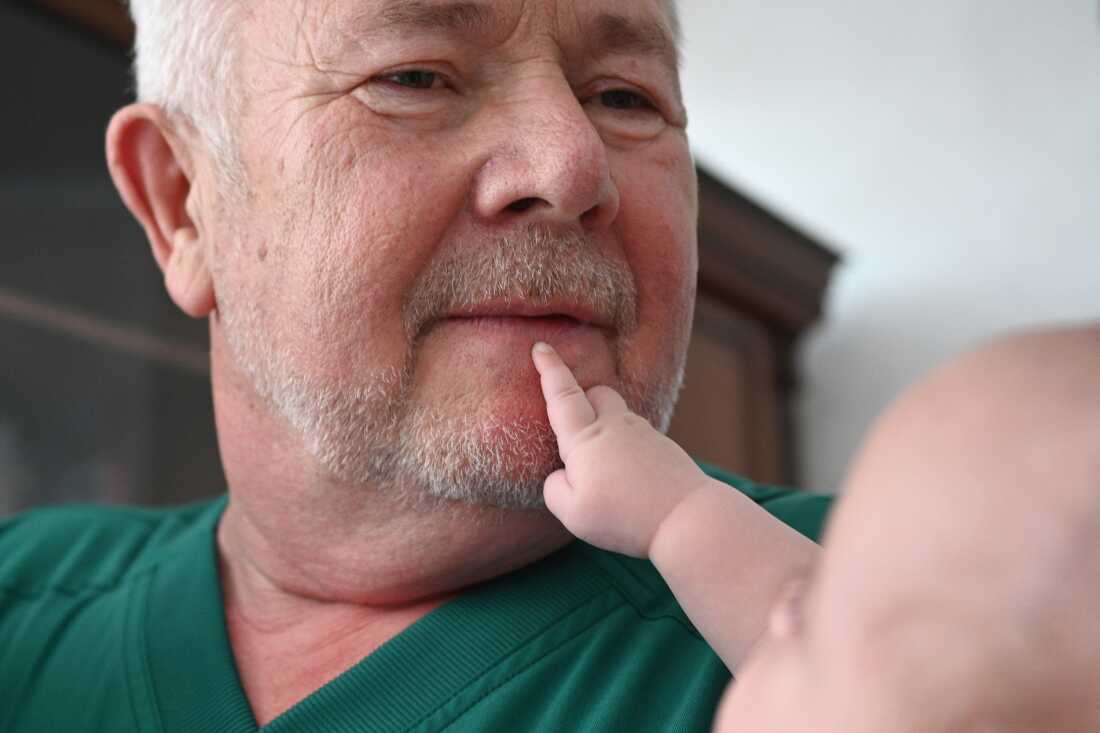 Dr. Stefan Khmil holds 4-month-old Angelina, born from artificial insemination, at his medical center, in Ternopil, Ukraine, on July 12.