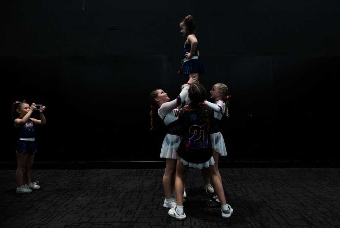 A young cheerleader takes a photo of her teammates practicing during the Frost Extreme cheerleading event in Wilmington, Delaware, on January 29, 2023. The majority of cheerleaders are girls aged 6-17.