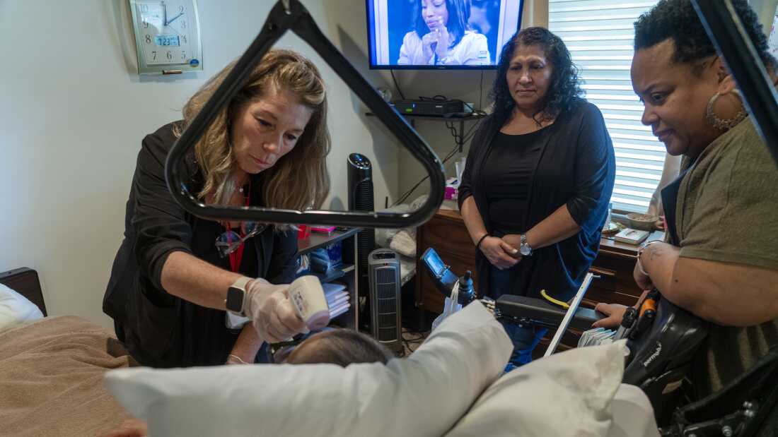 Visiting nurse Diane Morrison, left, examines Nathalia at her home in Brentwood, N.Y. on October 23, 2024 as Dawn (right) and Reina Mejia, a home health aide, look on.