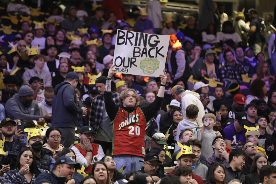 A fan hold up a sign in the stands urging the former Seattle Sonics basketball team to return to Seattle before a preseason NBA basketball game between the Los Angeles Clippers and the Portland Trail Blazers, Friday, Oct. 11, 2024, in Seattle. (AP Photo/John Froschauer)