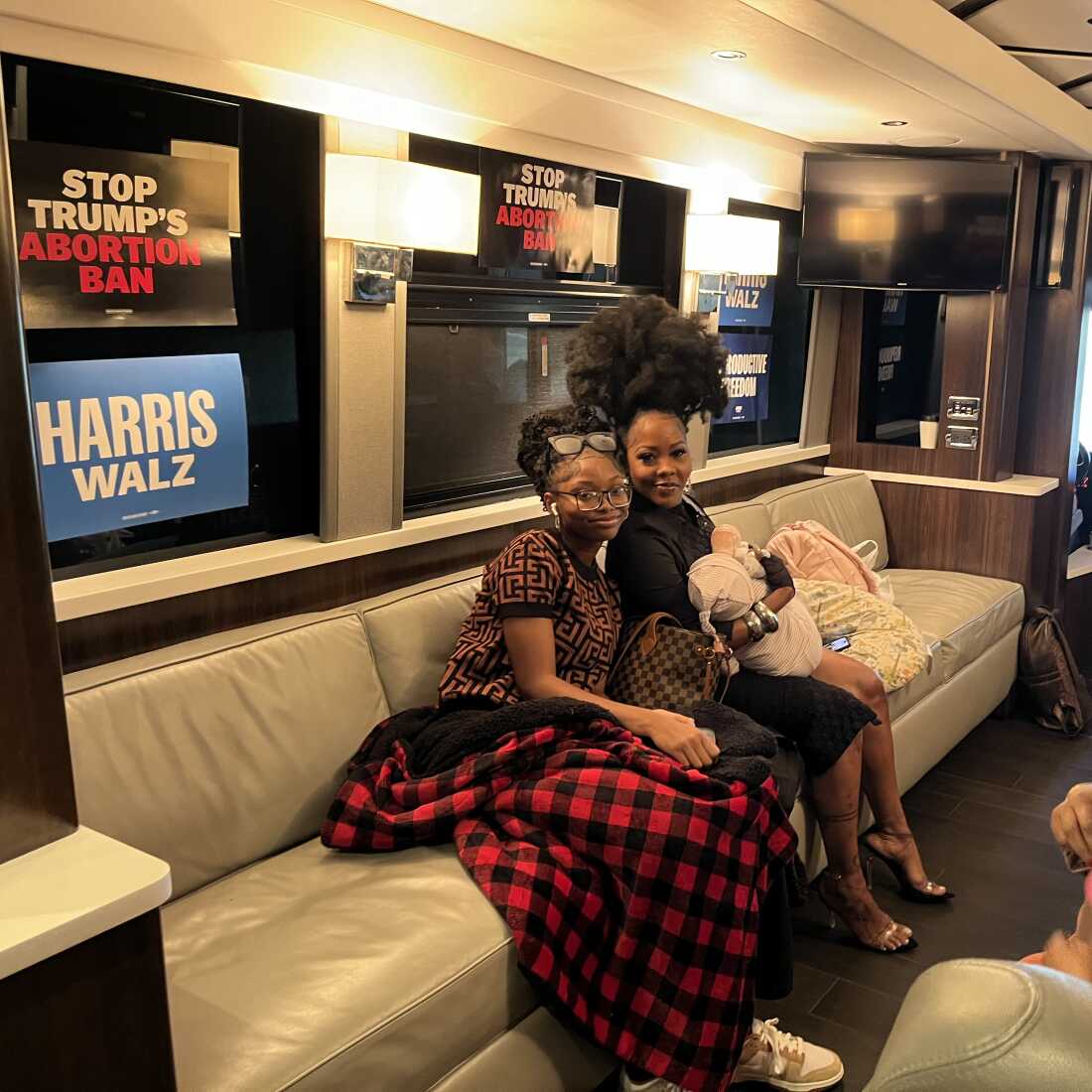 Nancy Davis rests for a moment with her daughters Asia (left) and Starr (in arms) inside the Fighting for Reproductive Freedom tour bus on Sept. 23, 2024 in Michigan.