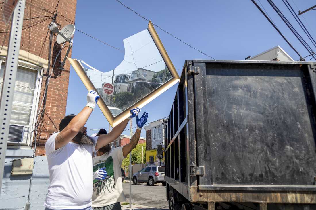 A local resident helps outreach worker Thomas Bradley (right) during a cleanup event in Philadelphia's Kensington neighborhood on Sept. 3, 2024. Bradley works with Ride Free, a local nonprofit focused on gun violence and neighborhood resilience.