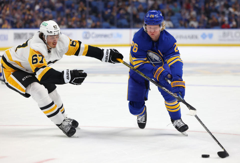 Oct 6, 2023; Buffalo, New York, USA; Buffalo Sabres defenseman Rasmus Dahlin (26) carries the puck as Pittsburgh Penguins right wing Rickard Rakell (67) defends during the second period at KeyBank Center. Mandatory Credit: Timothy T. Ludwig-Imagn Images